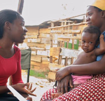 Outreach worker talks to mother with baby