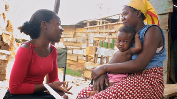 Outreach worker talks to mother with baby